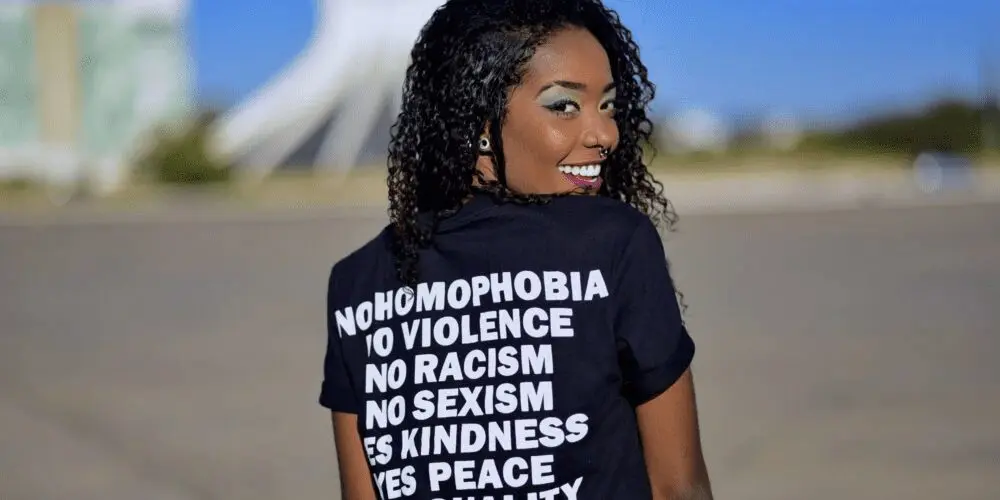 Woman turning and smiling at the camera wearing an equality t shirt.
