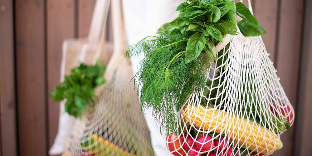 Shopping bags filled with vegetables.