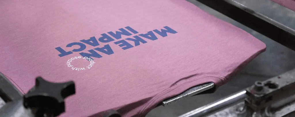 Screen printing on pink t shirt with text: "Make an Impact - products with purpose"