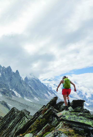 image example of Patagonia: Person wearing Patagonia gear running along the hill of a mountain top