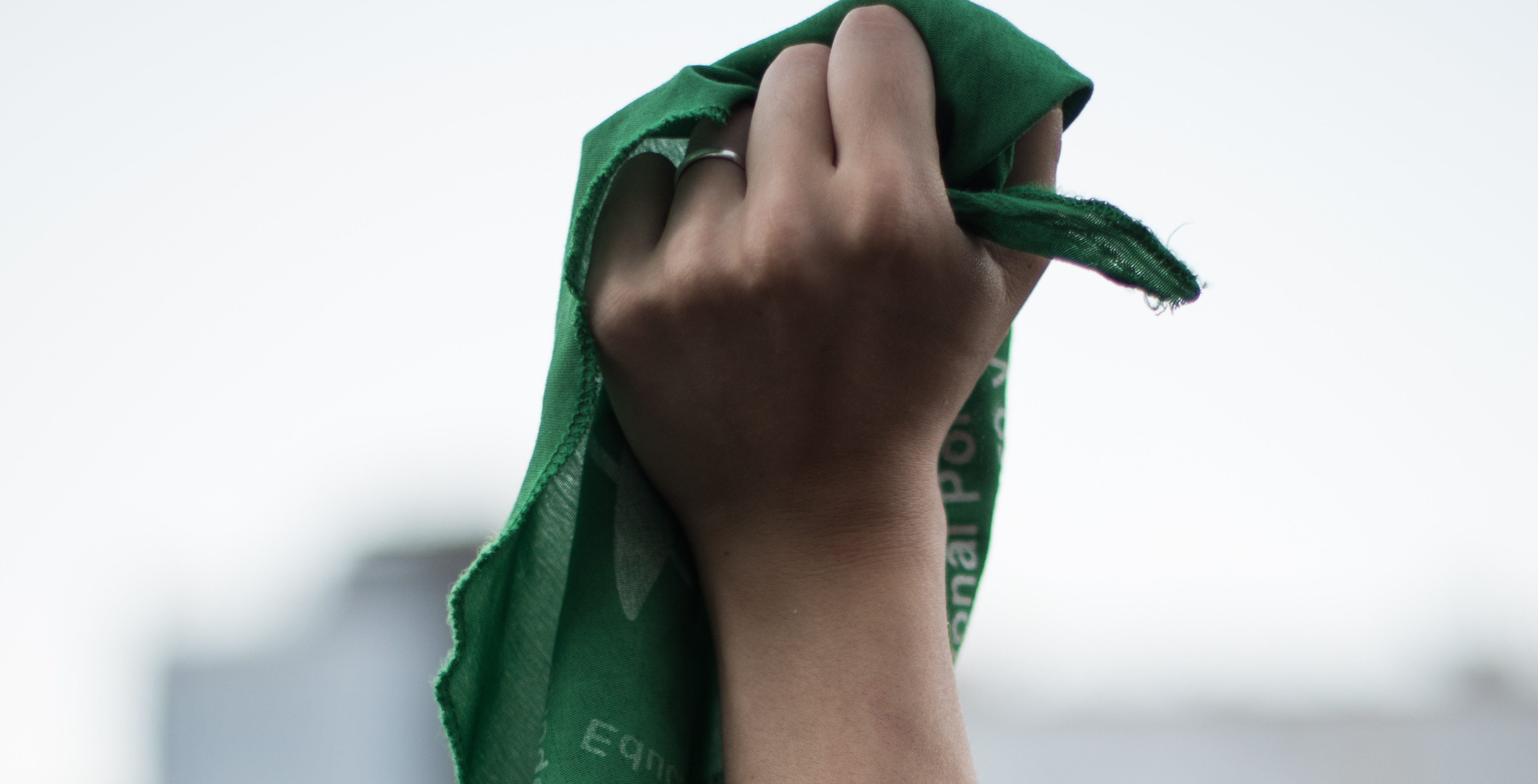 fist in air holding a green bandana