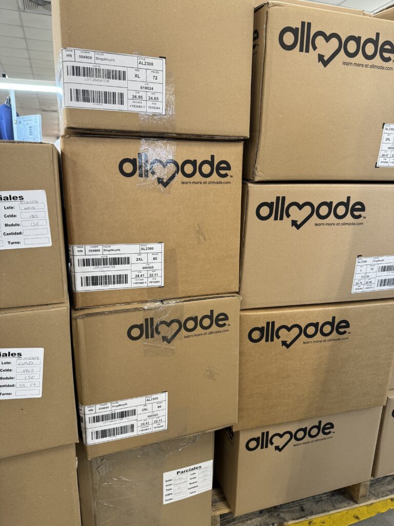 cardboard boxes stacked with allmade logo on them