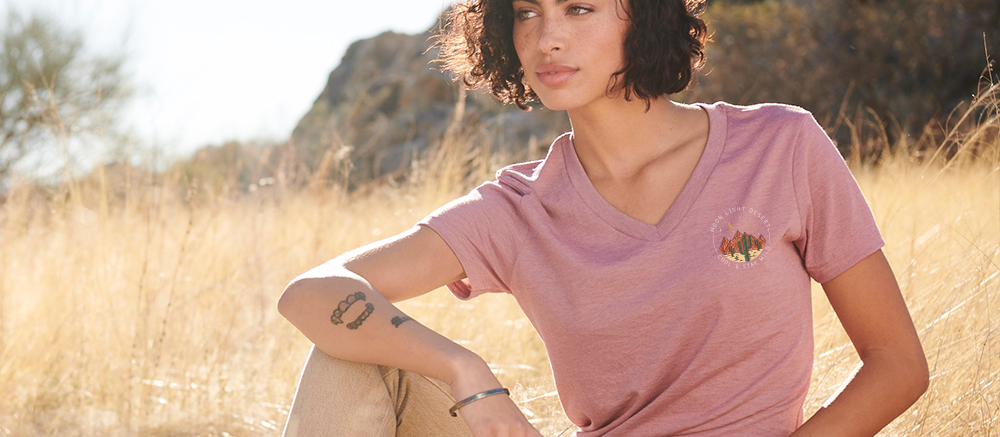 allmade shirt worn by a woman sitting in a grassy field