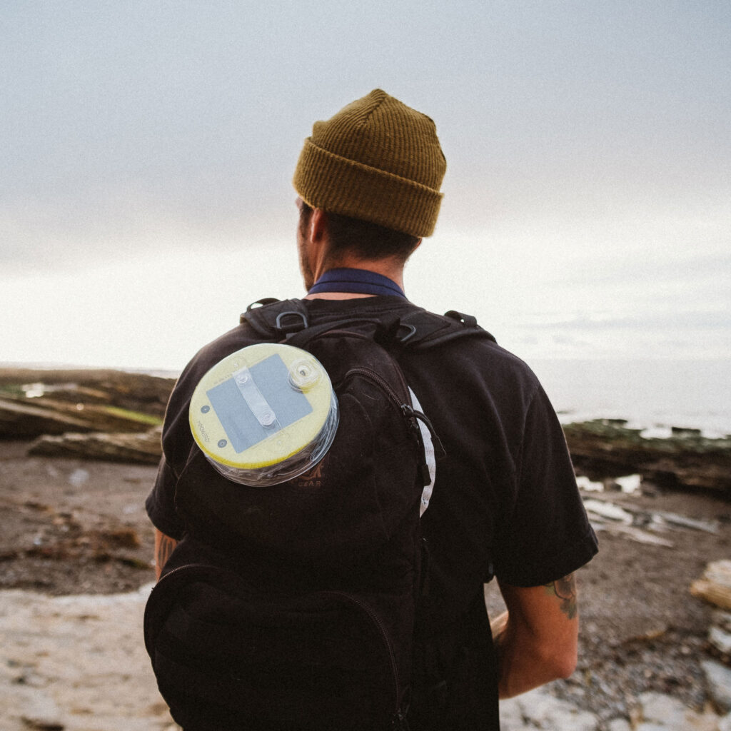 solar light on a backback being worn by a person looking at a mountain view