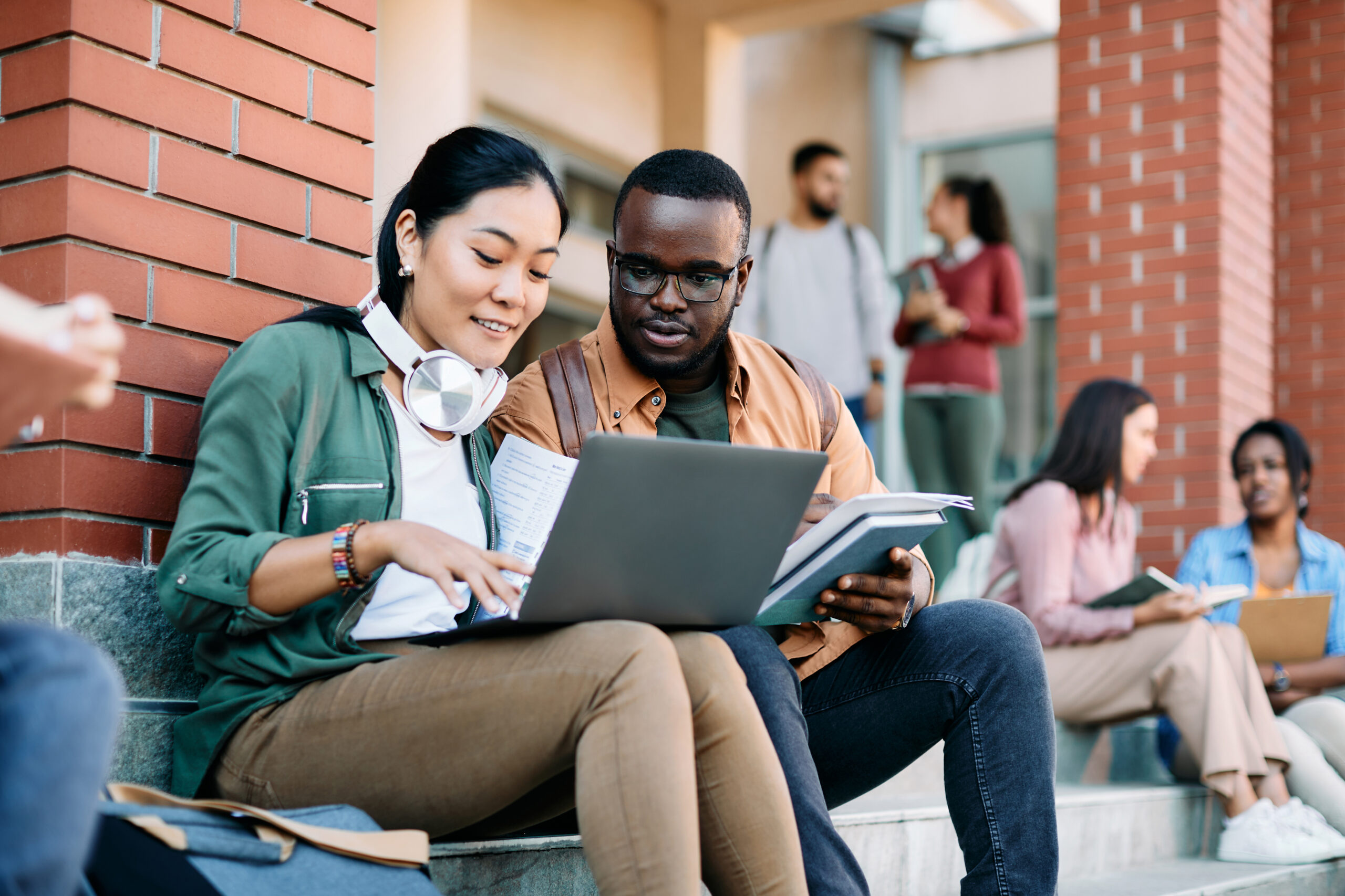 Young students use laptop while learning at campus.