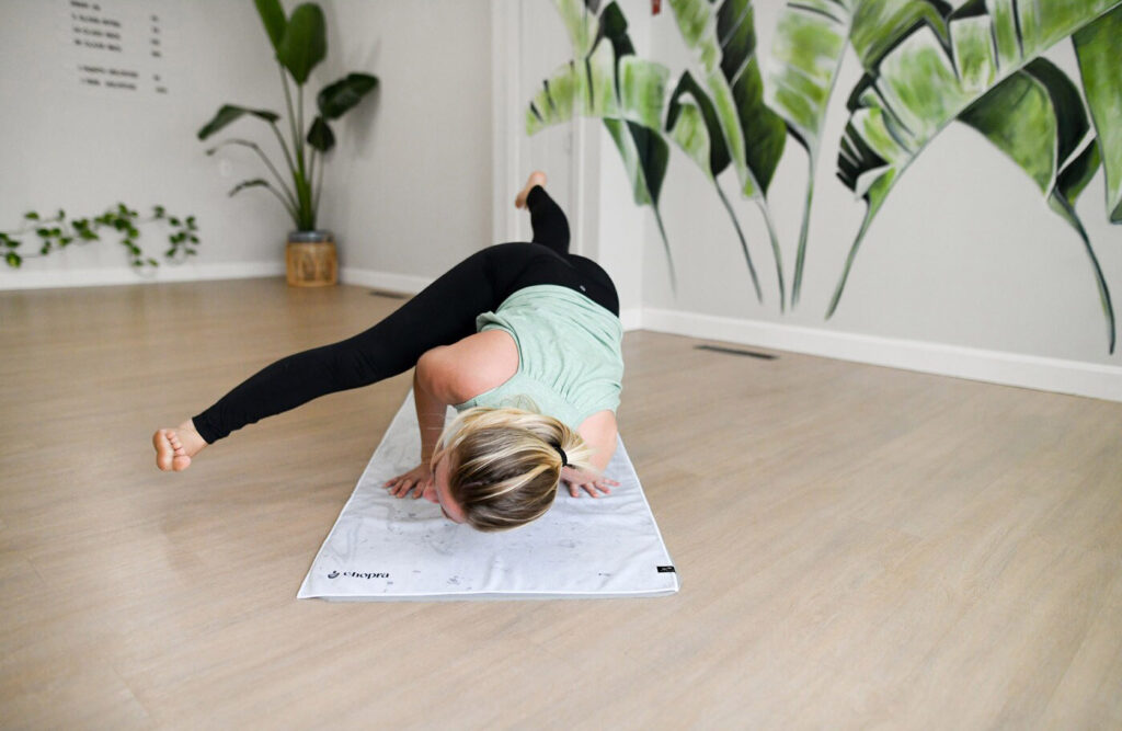 person in a yoga pose on a yoga towel