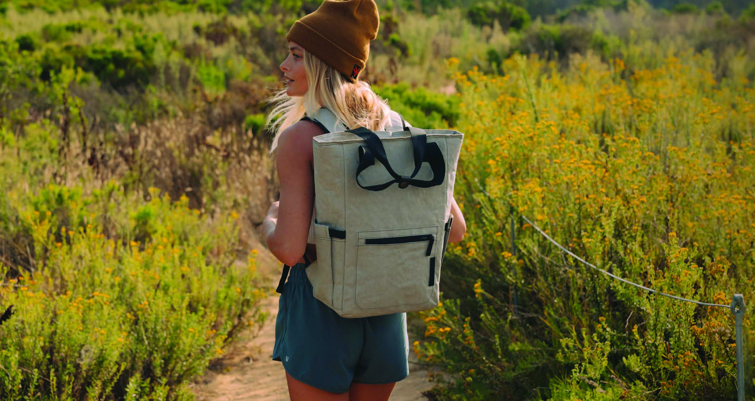 woman standing in a field wearing a backpack