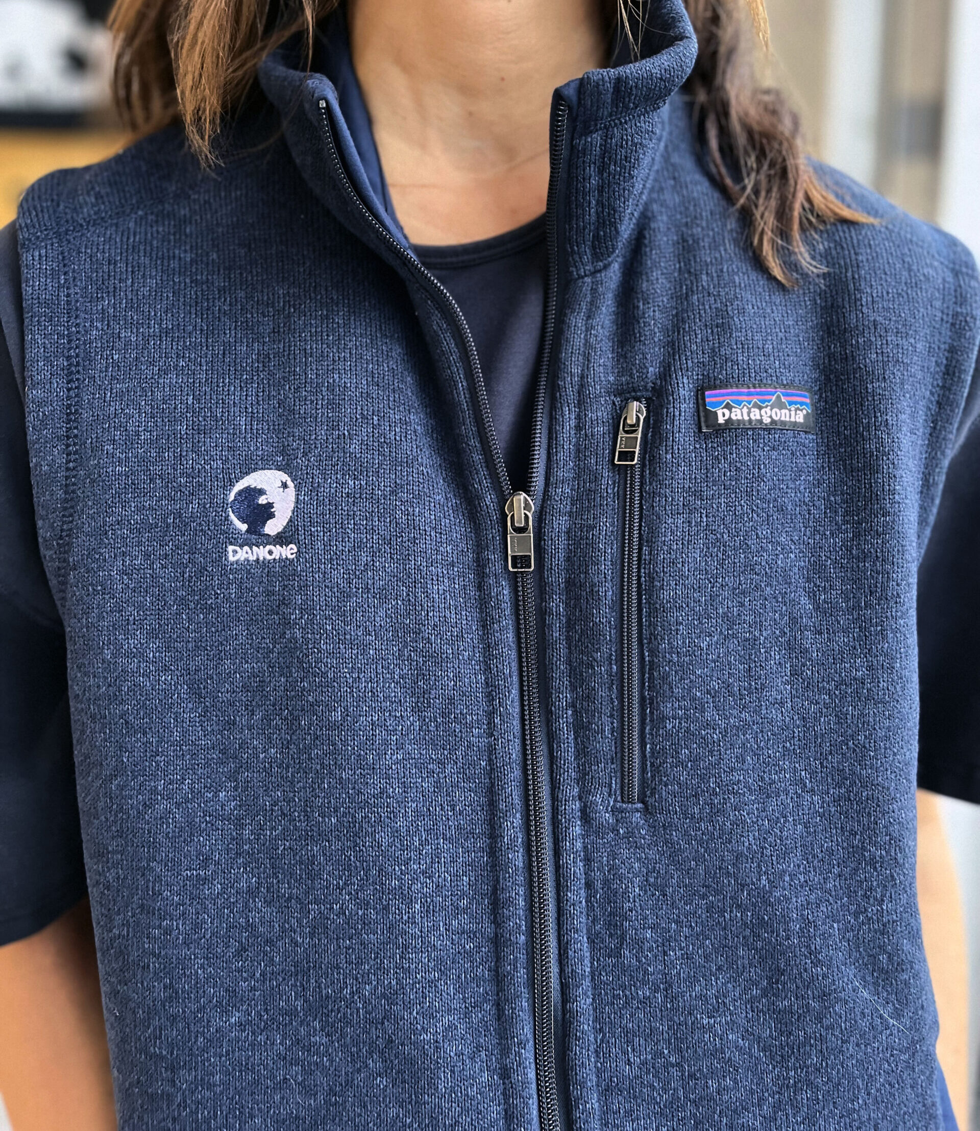 woman wearing a patagonia vest with danone embroidered logo right chest