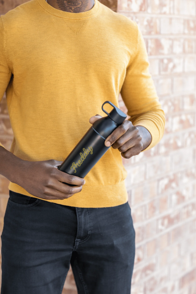 man holding water bottle with his name on it