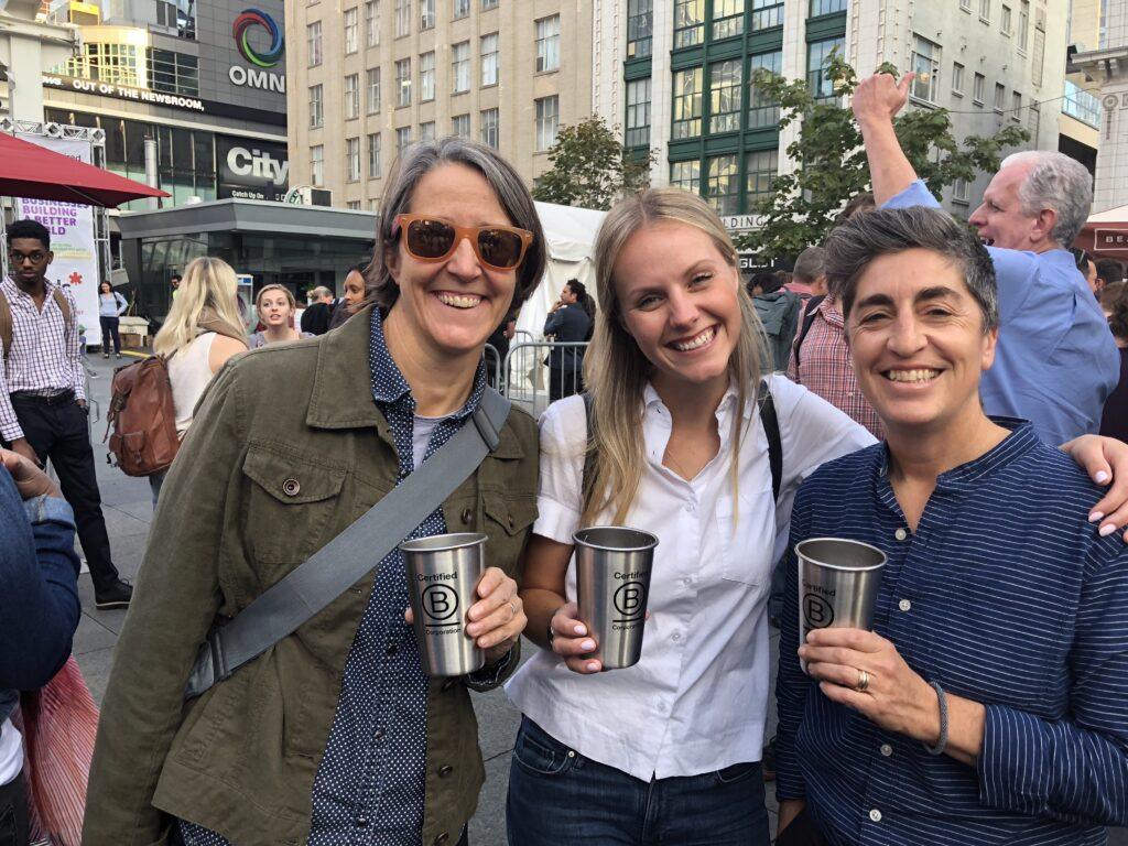 B Corp drinkware held by three people