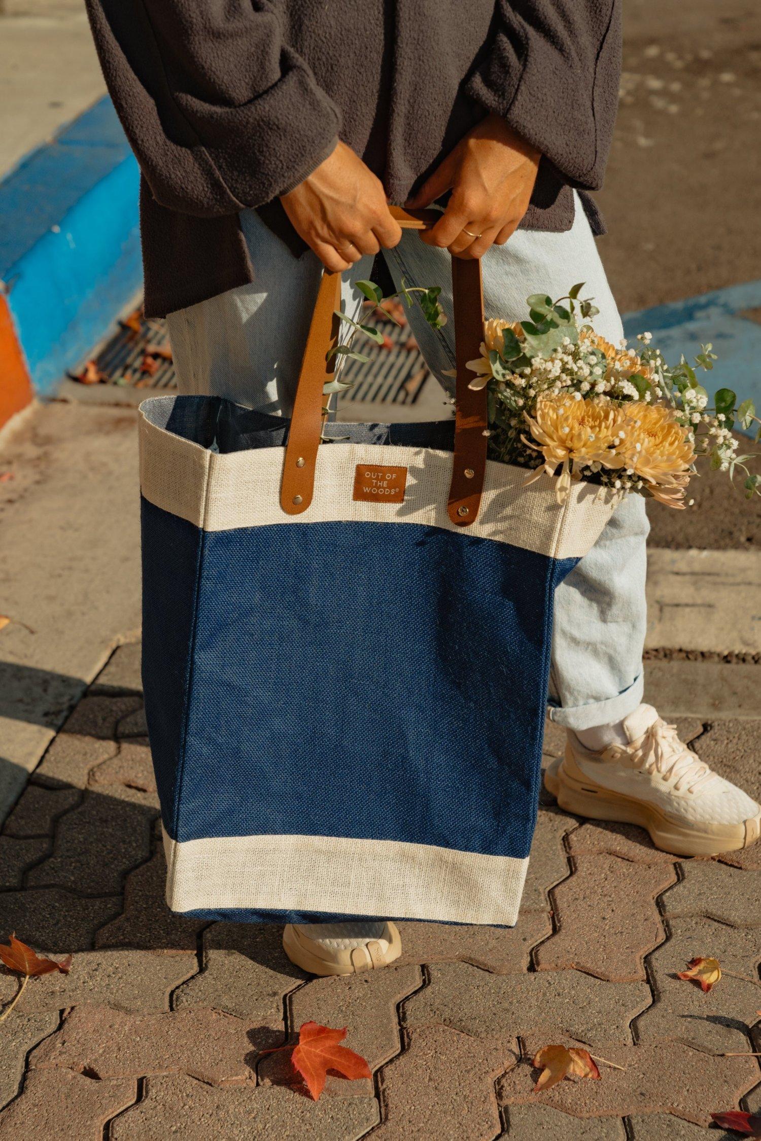 person holding a totebag filled with flowers