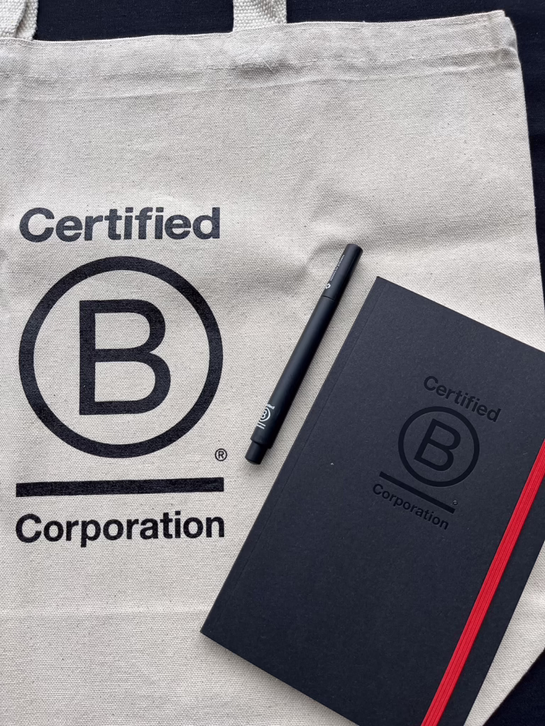 bcorp branding on a totebag notebook and pen