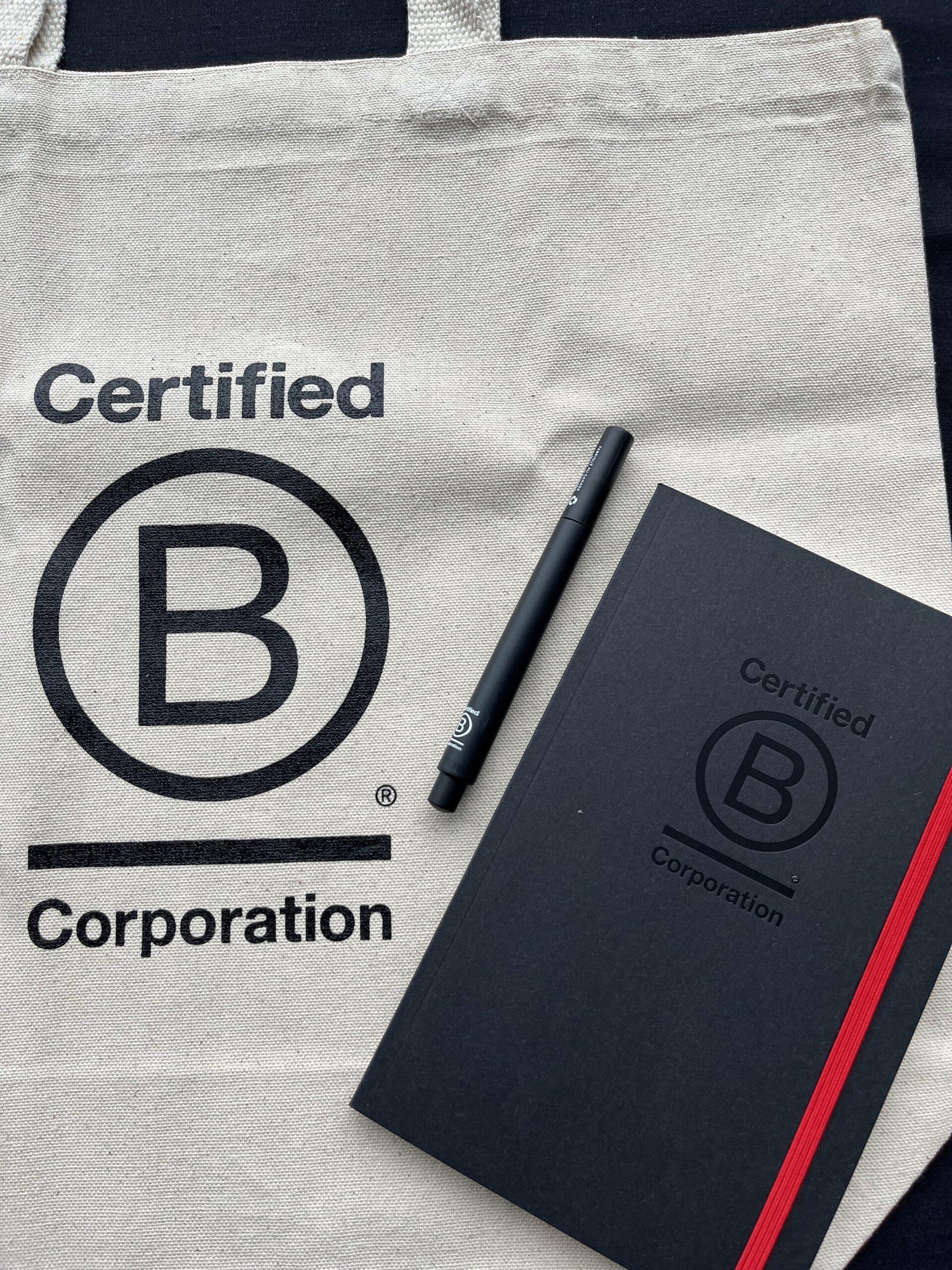 bcorp branding on a totebag notebook and pen