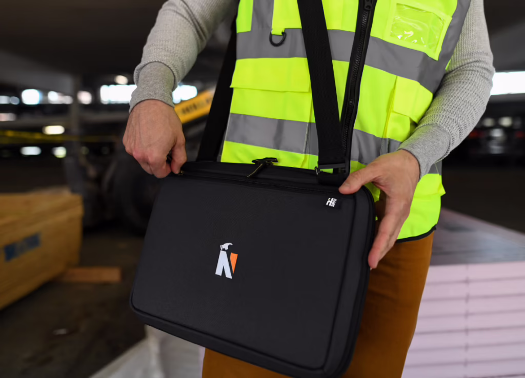 A person in a reflective vest carries a Heritage Supply Pro Padfolio & Construction Pen Set